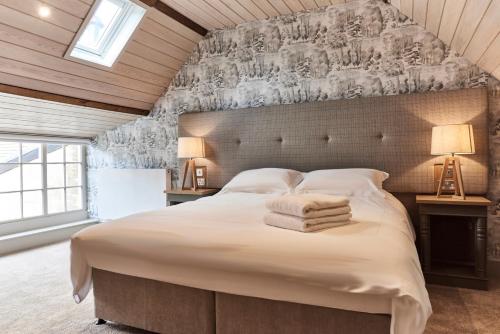 a bedroom with a large bed with towels on it at The Clocktower in Hexham
