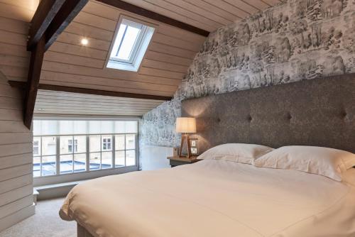 Un dormitorio con una gran cama blanca y una ventana en The Carriage House en Hexham