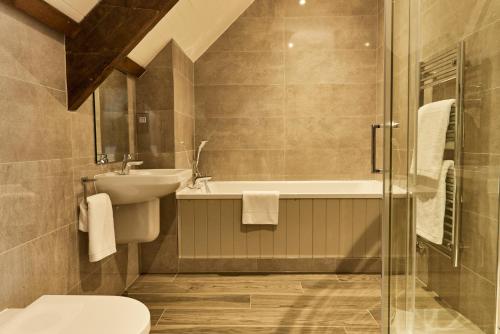 a bathroom with a sink and a toilet and a bath tub at The Carriage House in Hexham