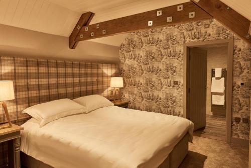 ein Schlafzimmer mit einem großen weißen Bett in einem Zimmer in der Unterkunft The Stalls in Hexham