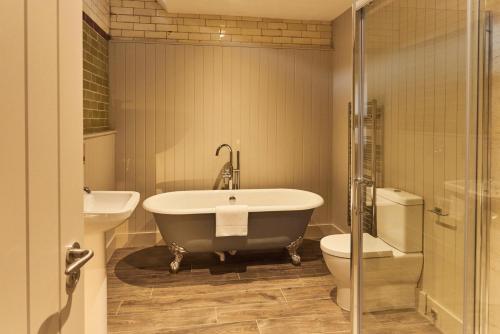 ein Badezimmer mit einer Badewanne, einem WC und einem Waschbecken in der Unterkunft The Stalls in Hexham