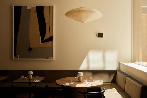 a dining room with two tables and a pendant light at Morgan & Mees Rotterdam in Rotterdam