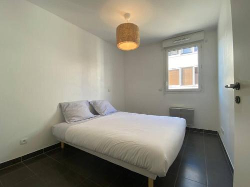 - un petit lit dans une chambre avec fenêtre dans l'établissement Très bel appartement cosy, à Palavas-les-Flots