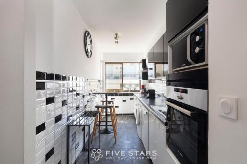 - une cuisine avec du carrelage noir et blanc sur le mur dans l'établissement City life Family FSHH -, à Nice
