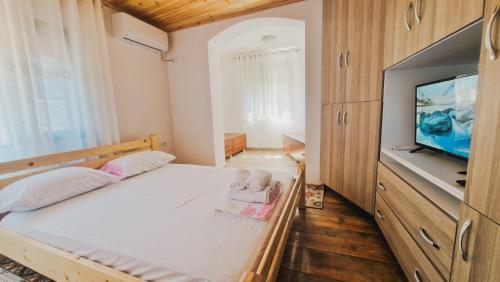 een slaapkamer met een bed en een flatscreen-tv bij Villa Kroi in Berat