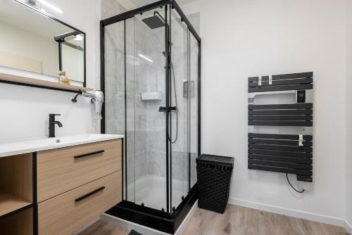 une salle de bain avec une douche en verre et un lavabo dans l'établissement Les Terrasses de Rangueil : studio avec parking, à Toulouse