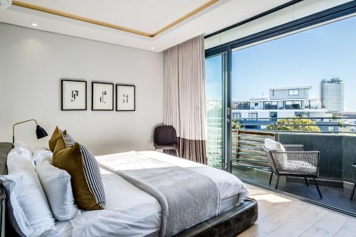 1 dormitorio con cama y ventana grande en Penthouse on S, en Ciudad del Cabo