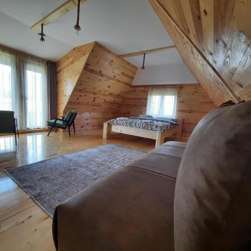 a bedroom with a bed in a room with wooden walls at Zelenova koliba in Žabljak
