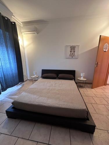 a large bed in a room with two tables at La Maison de Marianne in Trepuzzi