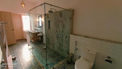 a bathroom with a shower with a toilet and a sink at Lockhart Bungalow Munnar - A CGH Earth SAHA Experience in Munnar