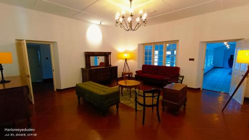a living room with a couch and a table and chairs at Lockhart Bungalow Munnar - A CGH Earth SAHA Experience in Munnar
