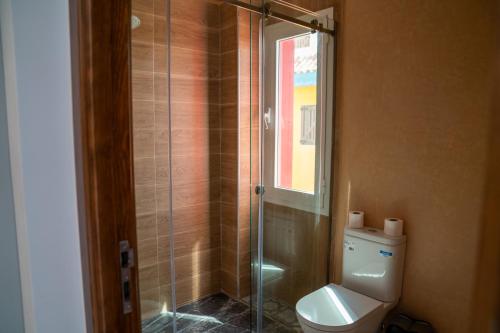a bathroom with a toilet and a glass shower at CASA DEL TITO in Oulad Akkou