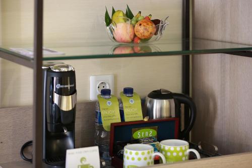 a shelf with a coffee maker and a bowl of fruit at SenS Hotel and Spa in Ubud