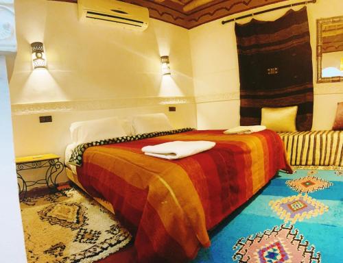 een slaapkamer met een bed met twee handdoeken erop bij Auberge La Fibule Du Dades in Aït Idaïr