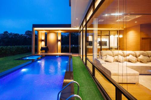 una piscina in una casa con un divano di Krajokkaew mouthten khao yai a Ban Khlong Yang