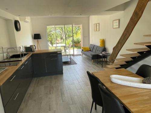 cocina y sala de estar con mesa y escalera en Cottage les Marjoris Tanneron, en Tanneron