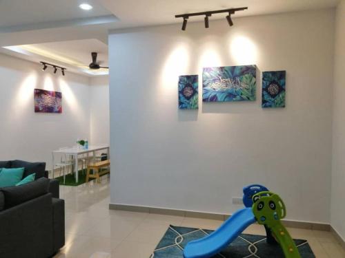 a living room with a couch and paintings on the wall at HOMESTAY BATU PAHATKU- HOMESTAY IMAN in Batu Pahat