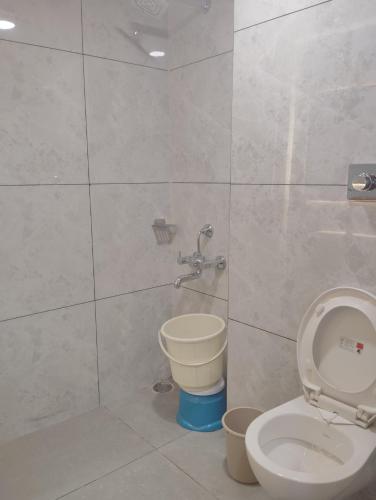 a bathroom with a toilet and a shower at Hotel CM Palace - Pure Vegetarian in Ner Chowk