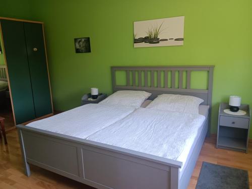 sypialnia z dużym łóżkiem i zielonymi ścianami w obiekcie Ferienwohnung Mattheiser Weiher w Trewirze