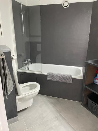 a bathroom with a white toilet and a bath tub at Appt Golfe de Saint-Tropez proche de la mer climatisé in Grimaud