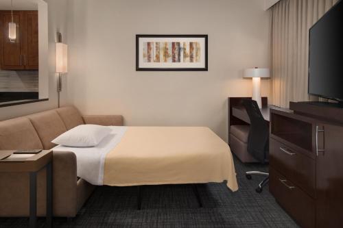 a hotel room with a bed and a couch at Residence Inn by Marriott Fairfax City in Fairfax