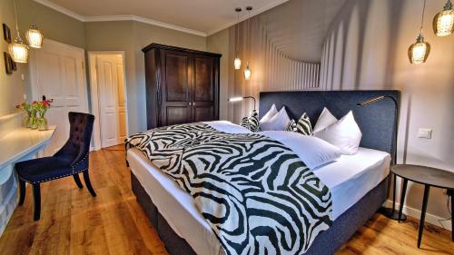 a bedroom with a zebra print bed and a desk at Boutique Hotel POST ANDECHS in Andechs