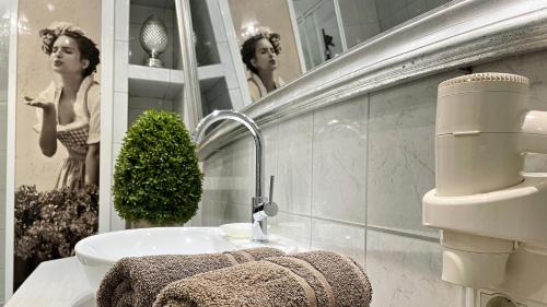 a bathroom with a sink and a mirror at Boutique Hotel POST ANDECHS in Andechs