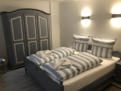 ヴェスターラントにあるFriesenhof Suderendeのベッド(青と白のストライプの枕付)