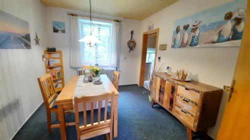 a dining room with a wooden table and chairs at Ferienhaus Nordseebrise in Holtgast