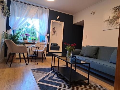 a living room with a blue couch and a table at Apartament Deluxe-Gontalowy in Kazimierz Dolny