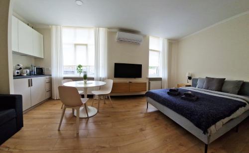 a bedroom with a bed and a table and a kitchen at Cēsu apartamenti in Cēsis