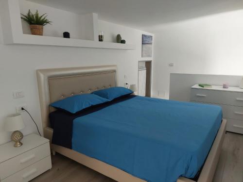 1 dormitorio con 1 cama con sábanas azules y almohadas azules en LA MAISON D&D en Margherita di Savoia