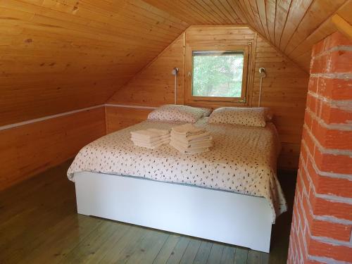 1 dormitorio con 1 cama en una cabaña de madera en ARIA, en Sviščaki