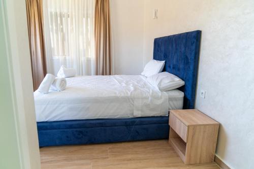 a bed with a blue headboard in a room at CASA DEL TITO in Oulad Akkou