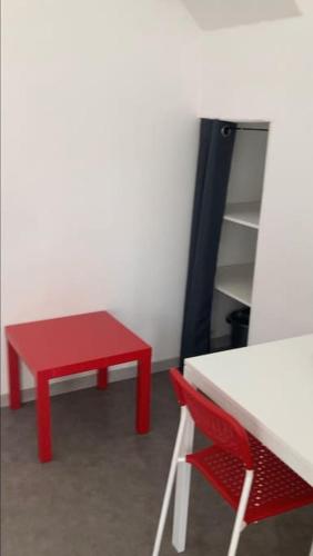 a red table and a red chair in a room at Studio au centre de Quimper RDC in Quimper