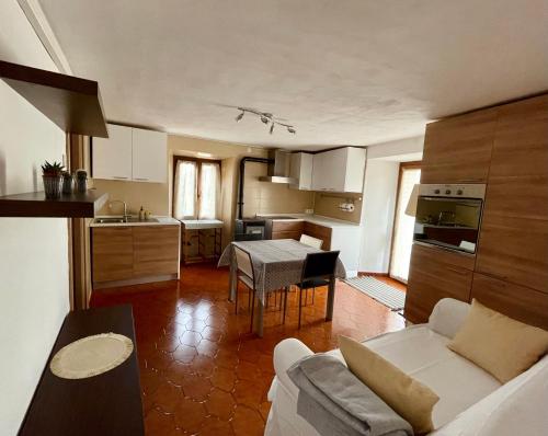 eine Küche und ein Wohnzimmer mit einem Sofa und einem Tisch in der Unterkunft Maison Merlot in Aosta
