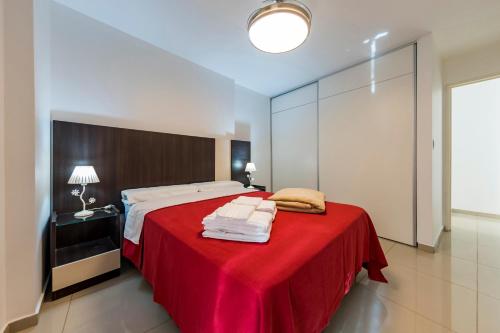 1 dormitorio con 1 cama grande con manta roja en Viaggiato Guemes en Córdoba