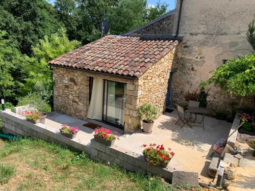 a small stone house with flowers in a yard at Maison Maria in Sainte-Nathalène