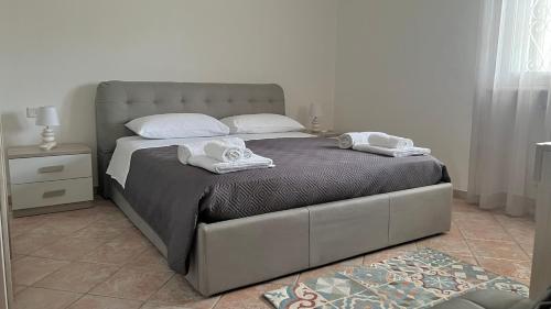 a bedroom with a large bed with towels on it at Villa Vedesa in Gallipoli
