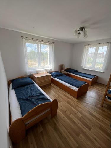 een slaapkamer met 2 bedden en 2 ramen bij Hostel Łódźka 52 in Toruń