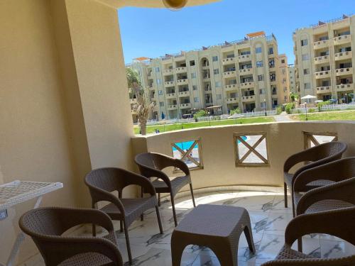 a balcony with chairs and tables and buildings at مرسى مطروح in Marsa Matruh