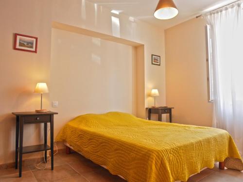 - une chambre avec un lit jaune et 2 tables dans l'établissement Appartement Le Palais, 2 pièces, 3 personnes - FR-1-418-95, au Palais