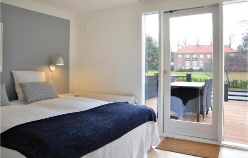 ヘルシンゲルにあるBeautiful Apartment In Helsingr With Wifiのベッドルーム1室(ベッド1台付)、スライド式ガラスドアが備わります。