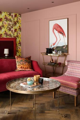 a living room with a red couch and a table at The Tempus at Charlton Hall Estate in Alnwick