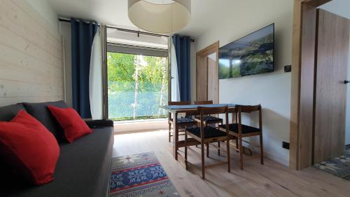 a living room with a couch and a table and a window at Villa Olimpijska 2 - Centrum in Wisła