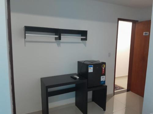 a room with a black table and a machine on a wall at Central Palace Hotel in Fortaleza