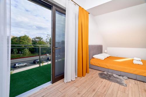 a bedroom with a bed and a large window at Warmia Apartments in Olsztyn