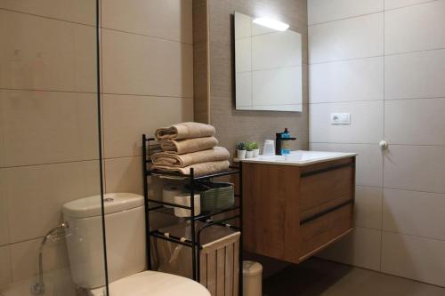 bagno con servizi igienici, lavandino e specchio di Apartamento Turístico HB a Villafranca