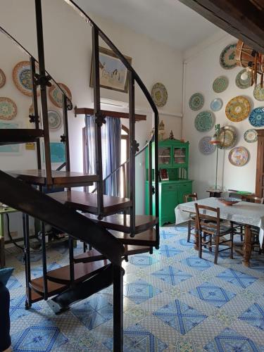a room with stairs and a table and plates on the wall at Casa Margherita in San Vito lo Capo