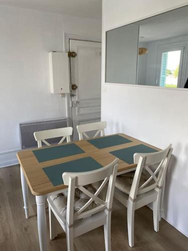 - une table à manger avec des chaises et un miroir dans l'établissement La loge en baie, à Saint-Valery-sur-Somme